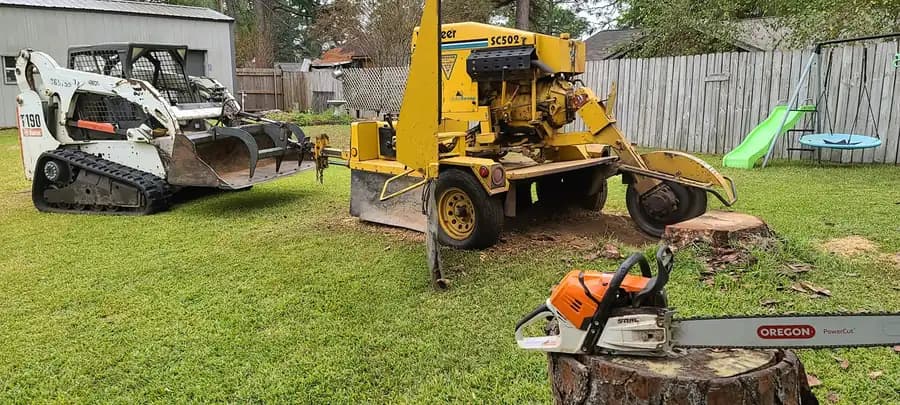 Stump grinder and compact loader used for tree service work