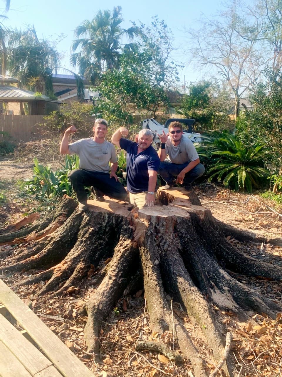 Bordelon's crew standing beside a large tree after removal