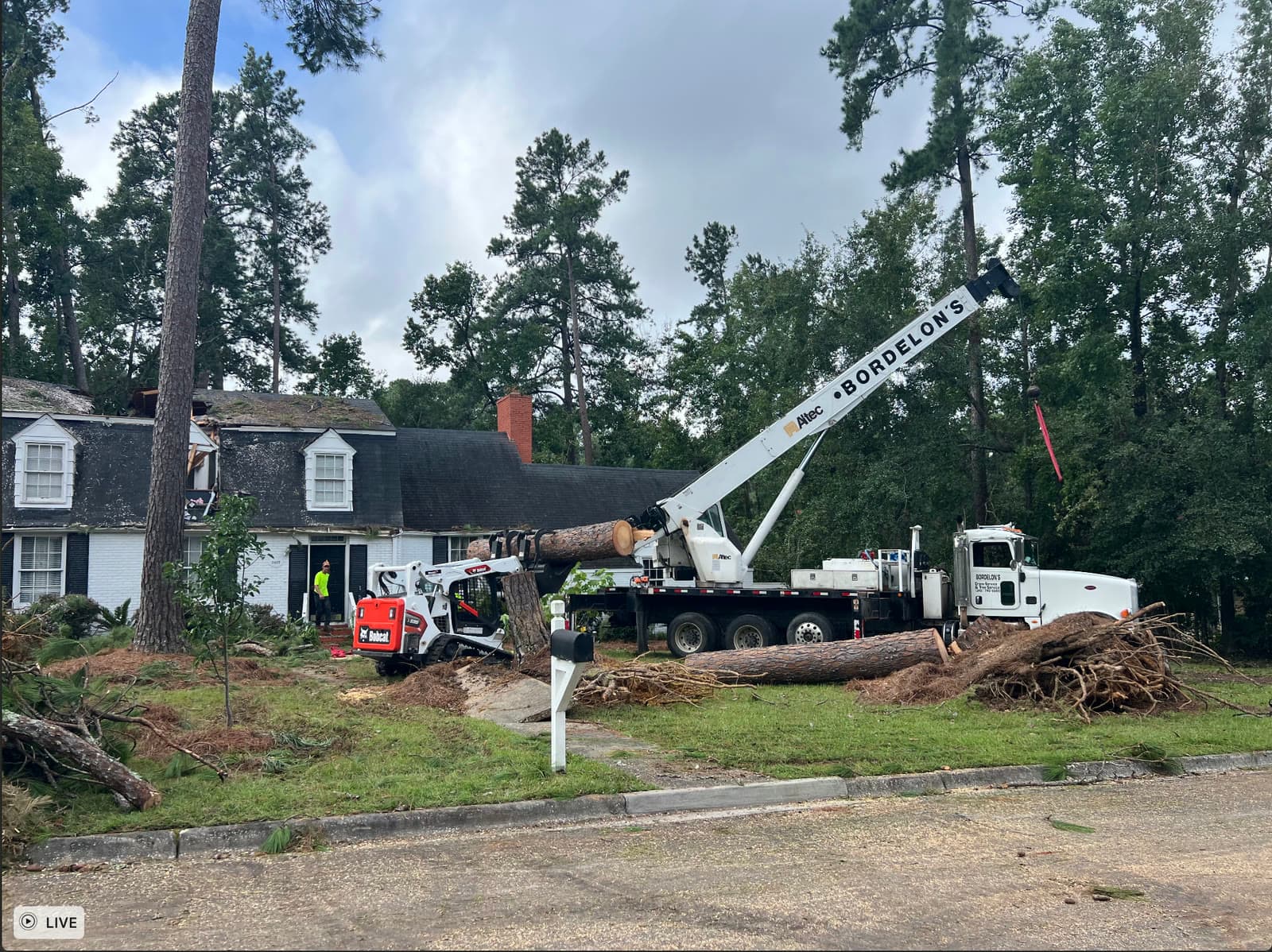 Crane and loader operating in front of a house